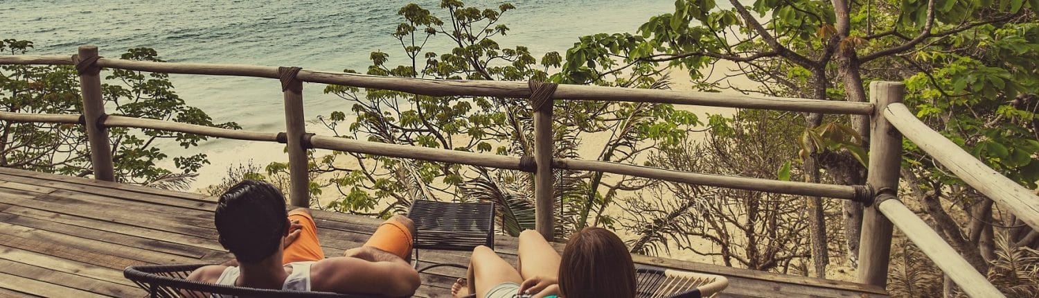 Moving to Riviera Nayarit Mexico - image of couple sitting on balcony overlooking the beach