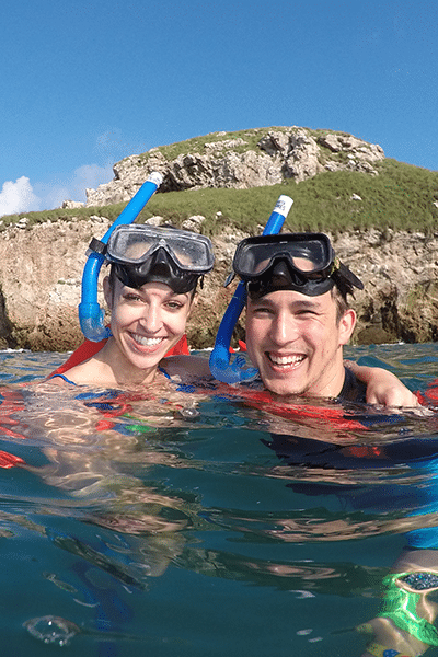 Young couple in snorkelling gear posing for a photo