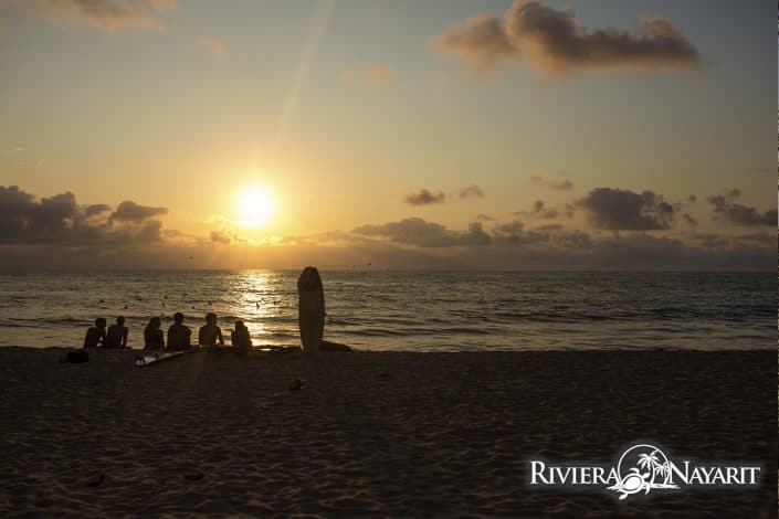 Surfers sitting on the beach at Sunset in San Pancho Riviera Nayarit Mexico