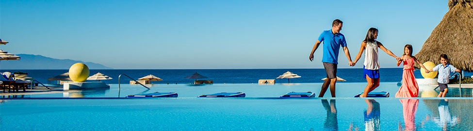 Young Family walking along the edge of Gran Venta infinity pool